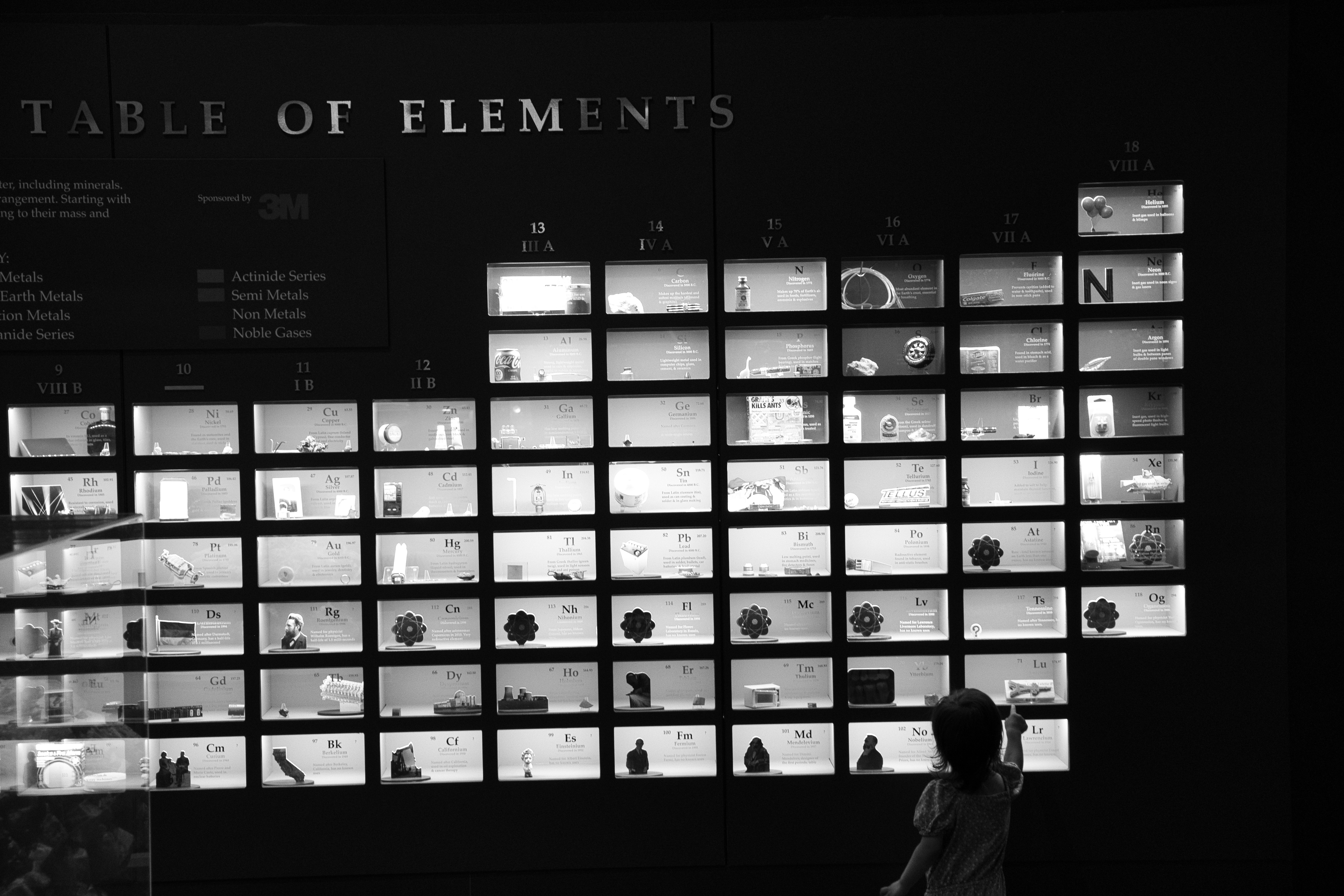 a young girl at a museum exhibit for the periodic table of elements
